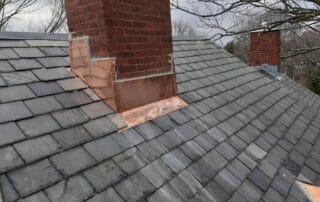 A photo of two chimney's illustrating specialty copperwork and slate roof.