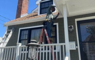 A close-up photo showing the ongoing installation of asphalt shingles on a residential roof, with synthetic underlayment and Timberline HD roofing material visible.